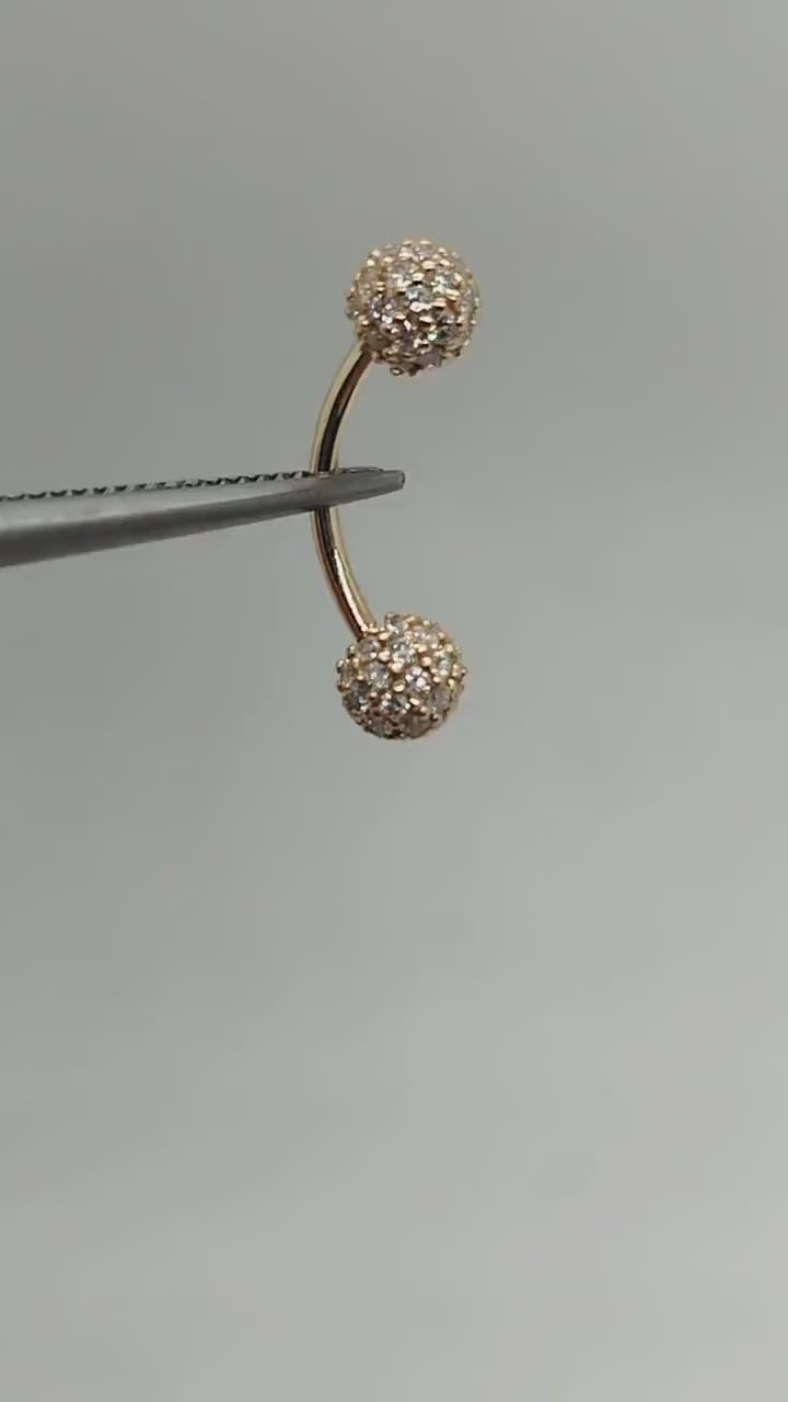 yebrow piercing - a 14k gold curved barbell adorned with exquisite white diamonds.