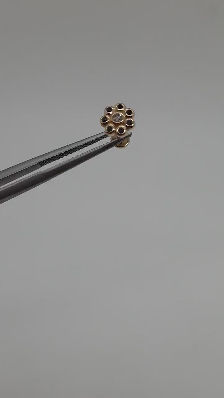 This labret piercing stud is crafted from 14k solid gold, featuring a stunning white diamond at the center of the flower. Surrounding it are black diamonds.