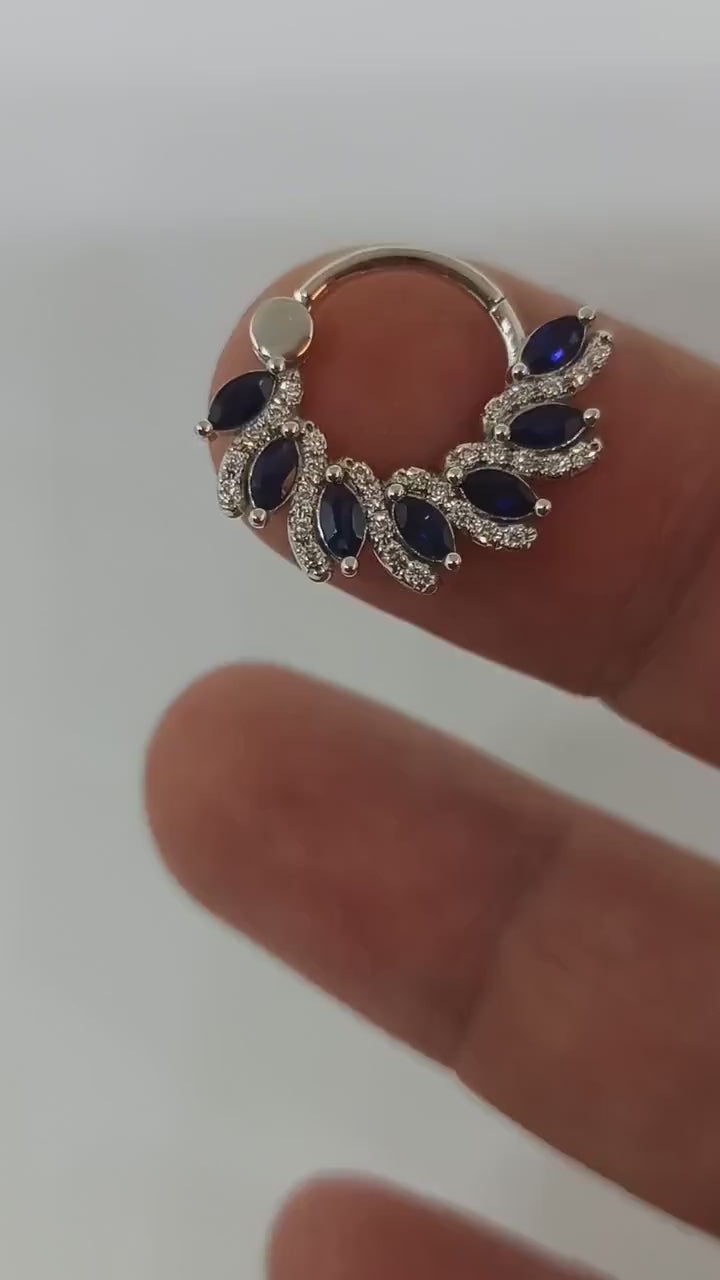 This 14k solid gold clicker showcases a magnificent marquise sapphire, making it a luxurious and unique piercing